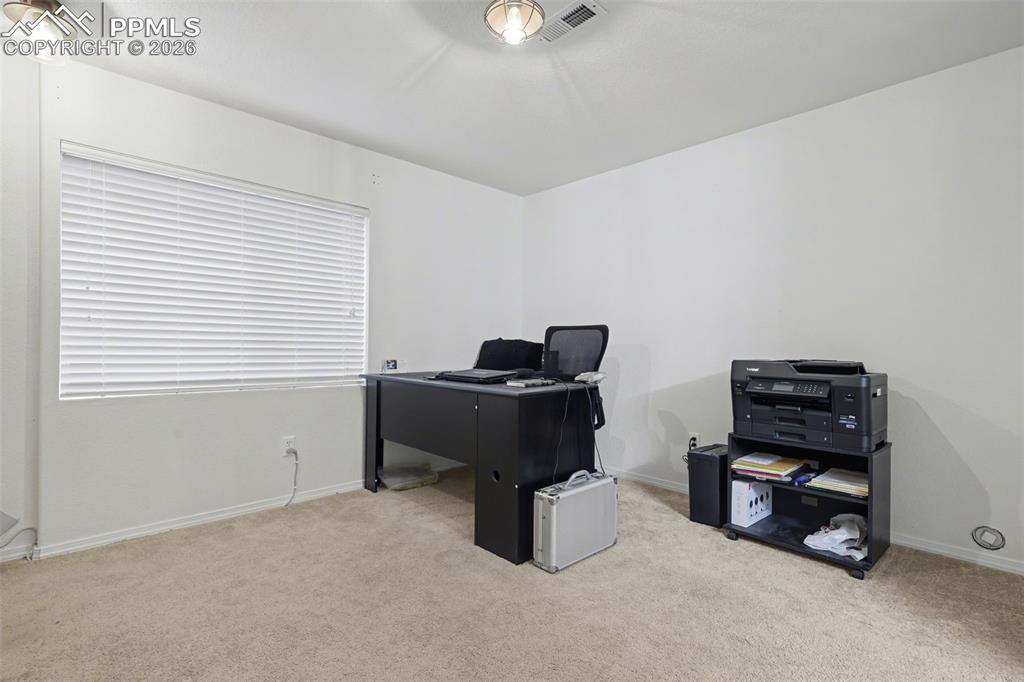Image 11 of 15: Family room in basement, currently set up as an office.