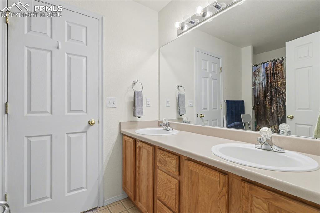 Image 7 of 15: Upper level full bathroom with dual vanity sinks