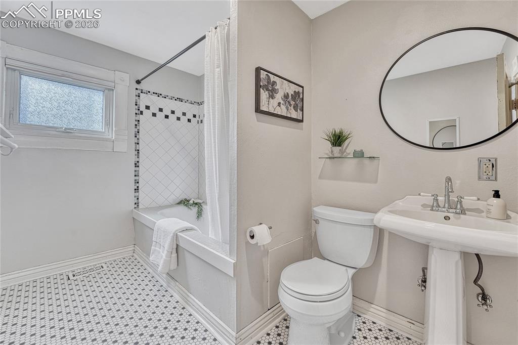 Image 25 of 42: A classic pedestal sink and tasteful tilework maintain the Victorian feel f