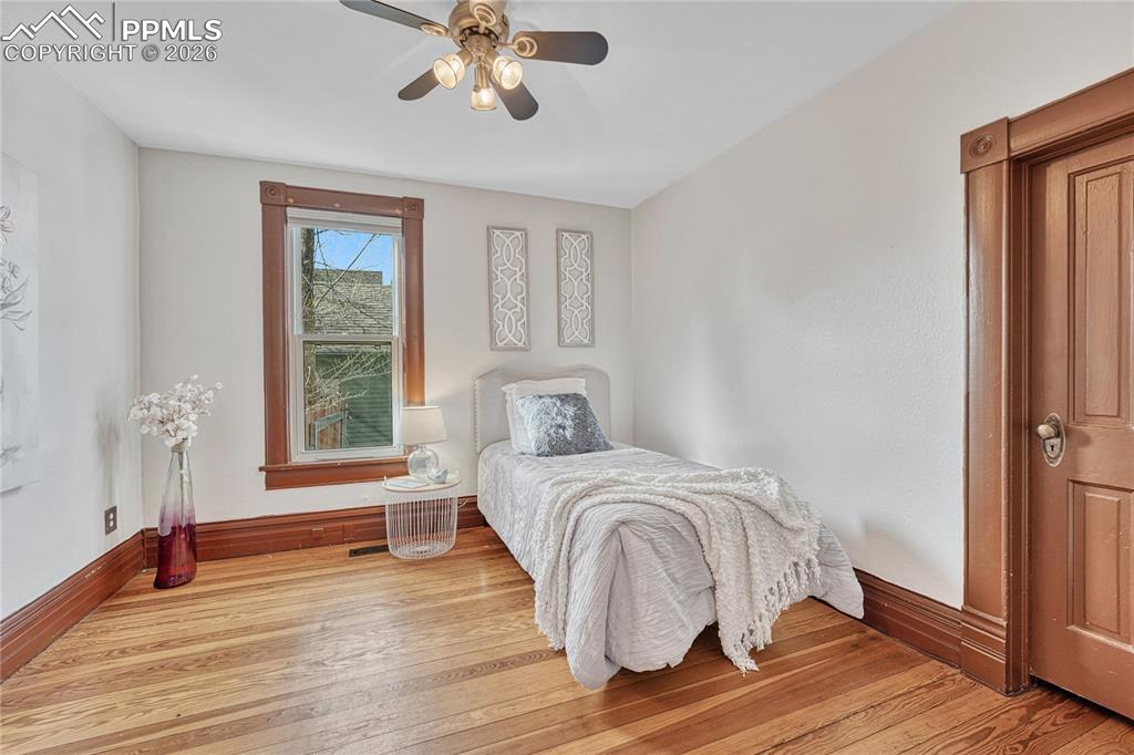 Image 7 of 42: This guest bedroom features beautiful natural wood floors and the added con