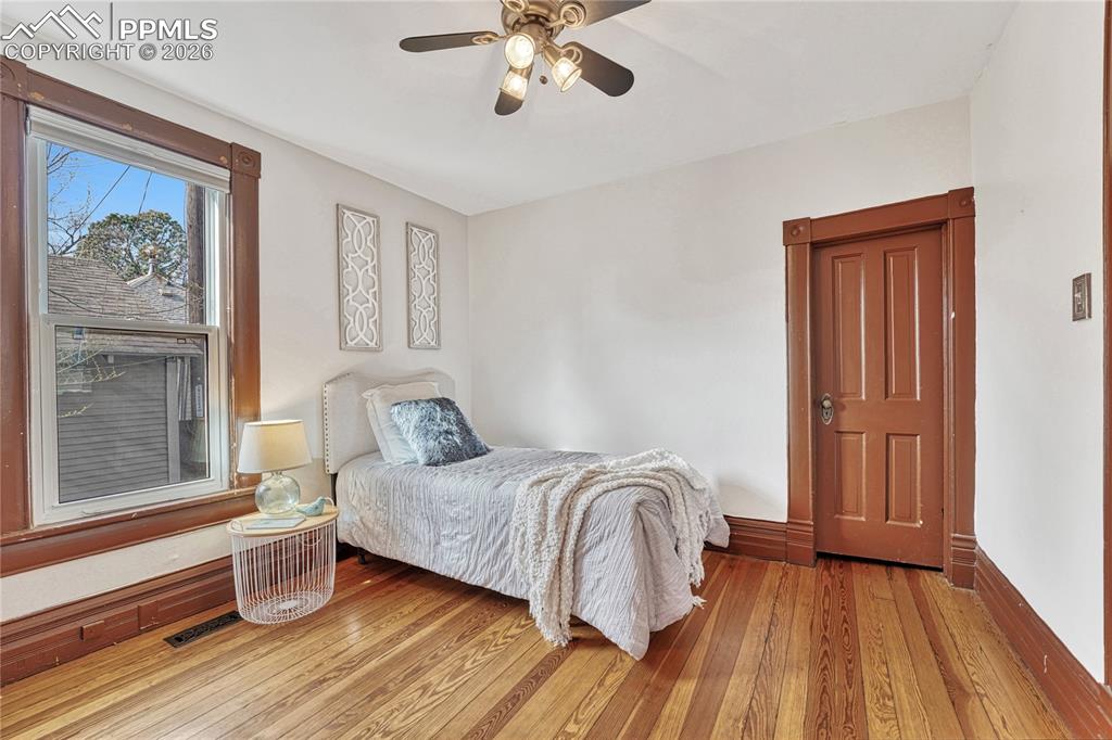 Image 8 of 42: A ceiling fan, custom shades, and updated vinyl windows ensure this bedroom