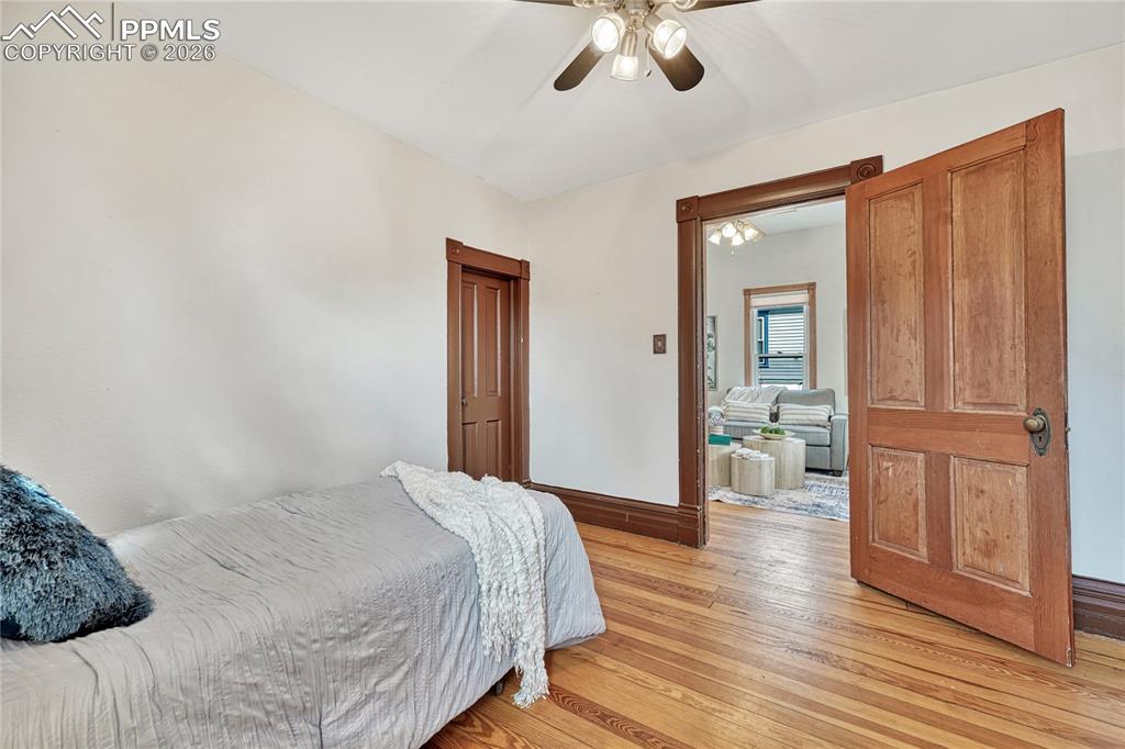 Image 9 of 42: Solid doors and thick historic wood trim tie this secondary bedroom seamles