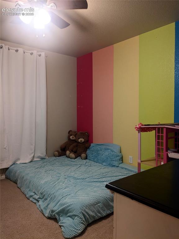 Image 19 of 33: Carpeted loft area featuring a partial wall with a railing and an overhead 