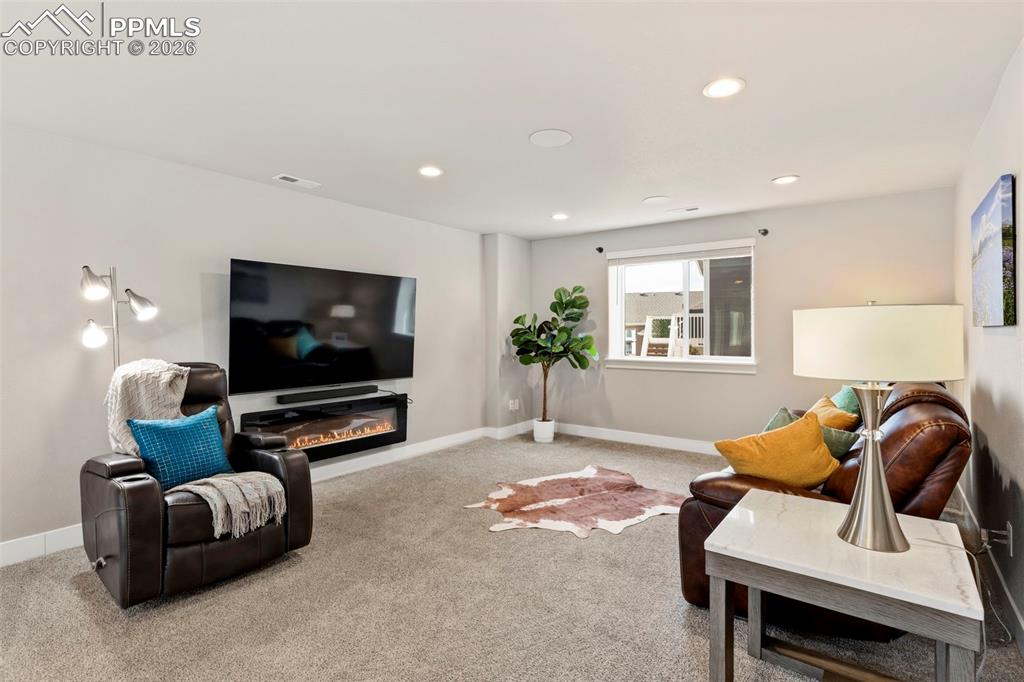 Image 13 of 45: Carpeted living area featuring recessed lighting and a glass covered firepl