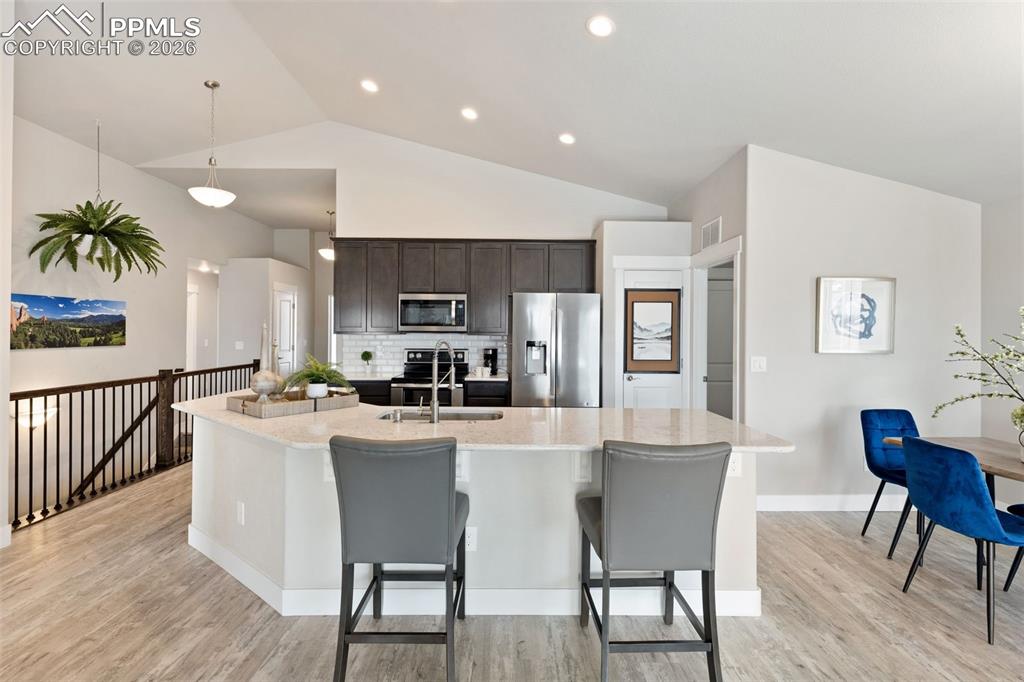 Image 18 of 45: Kitchen with stainless steel appliances, vaulted ceiling, dark wood finish 