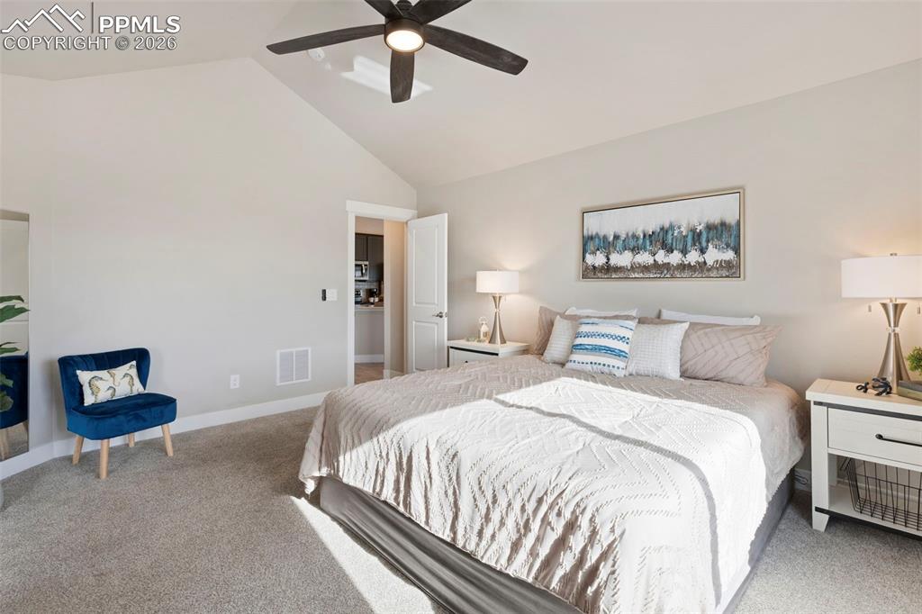 Image 20 of 45: Bedroom with carpet, a ceiling fan, and a high ceiling