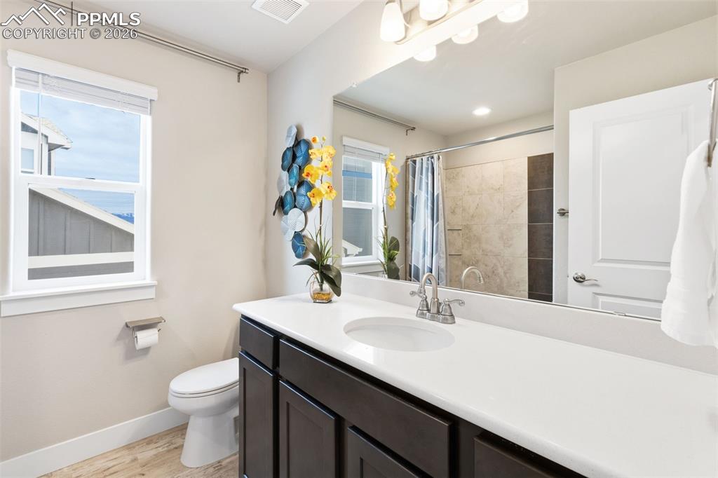 Image 24 of 45: Bathroom featuring vanity, light wood-style floors, and a shower with curta