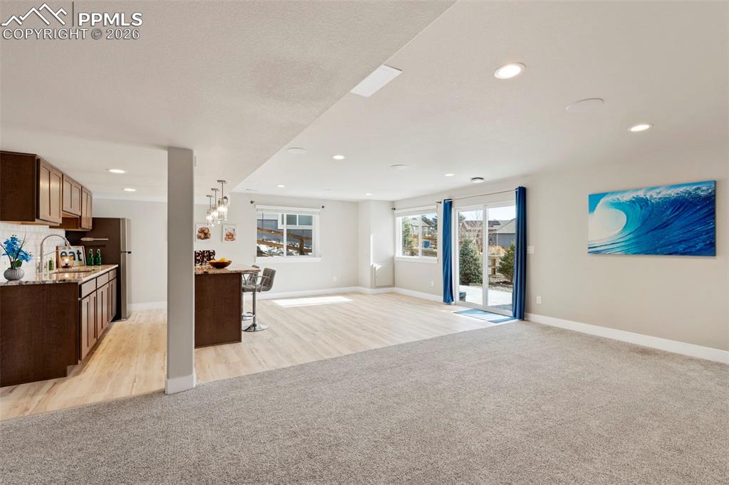 Image 28 of 45: Living area with light carpet and recessed lighting