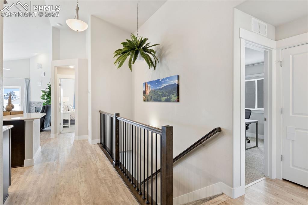 Image 3 of 45: Hallway with light wood-type flooring, vaulted ceiling, and an upstairs lan