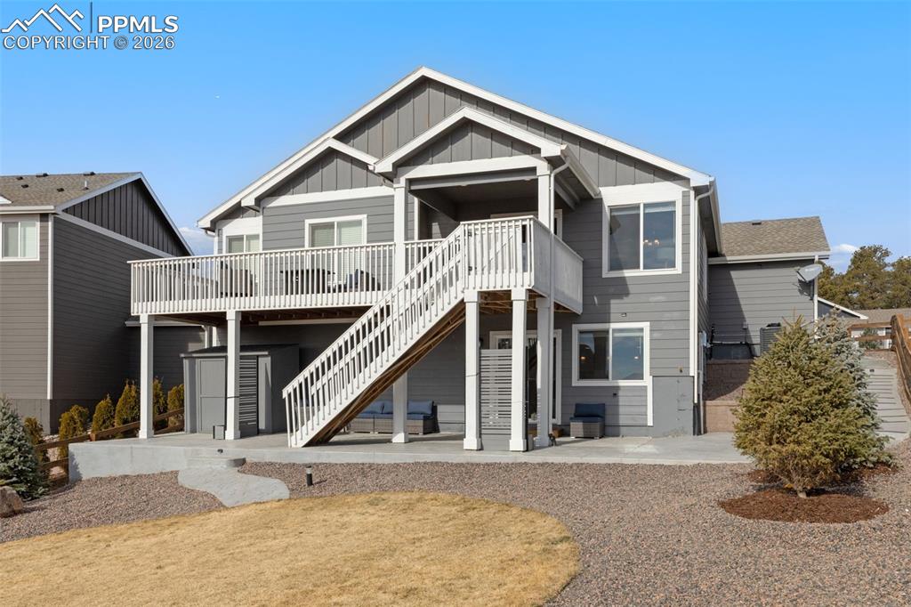 Image 36 of 45: Back of property featuring a patio area, board and batten siding, and a woo