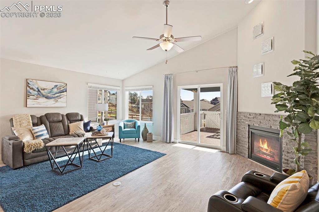 Image 4 of 45: Living area with lofted ceiling, ceiling fan, a glass covered fireplace, an
