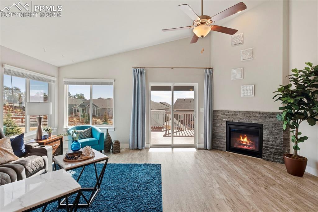 Image 5 of 45: Living area featuring vaulted ceiling, light wood-style floors, a fireplace