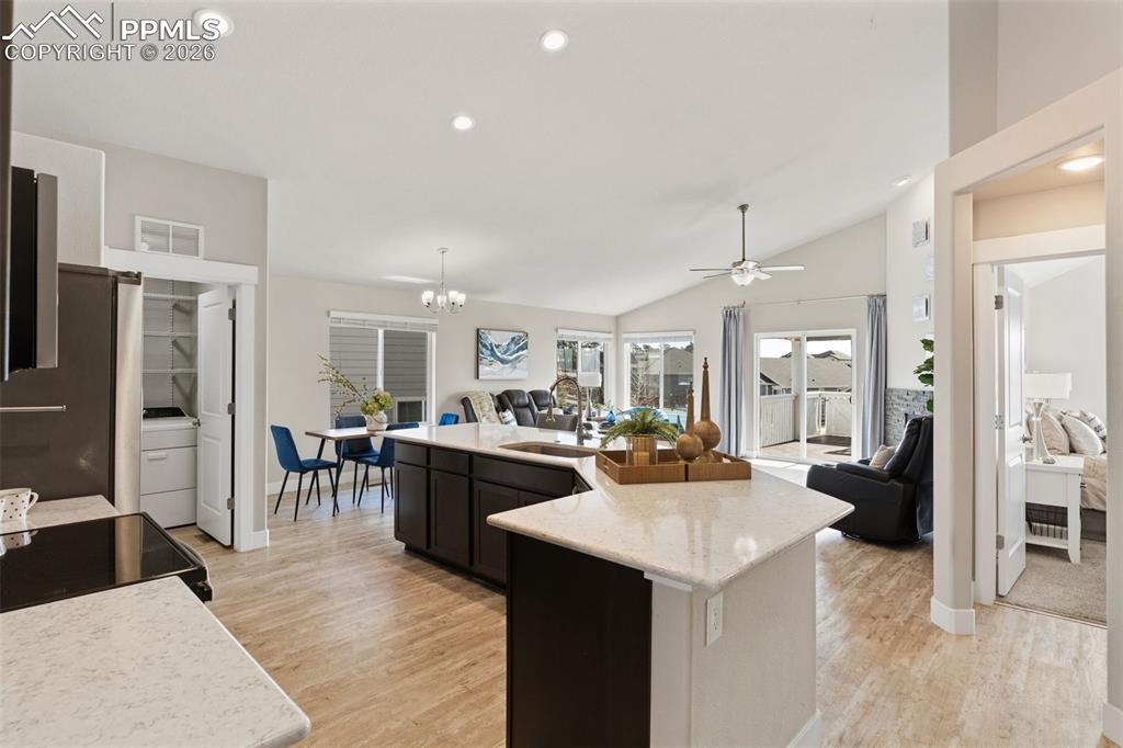 Image 7 of 45: Kitchen with open floor plan, freestanding refrigerator, light wood-style f