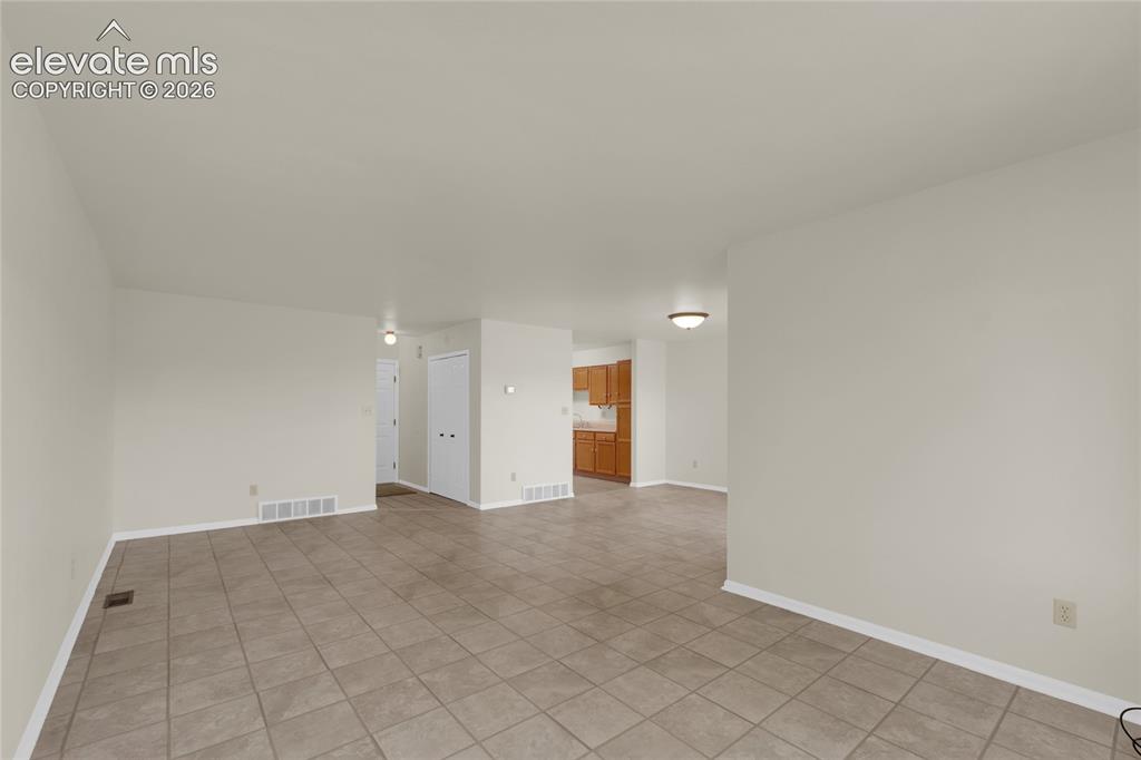 Image 12 of 33: Living Room looking toward the front hallway, dining area and kitchen