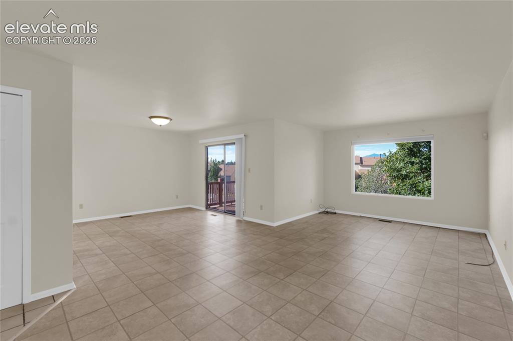 Image 13 of 33: Living and dining area with walk-out to deck