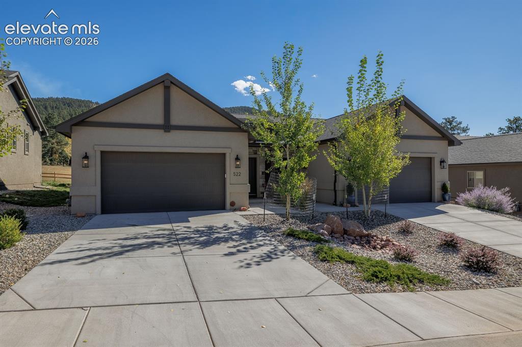Image 2 of 16: Stucco exterior with gable rooflines, attached two-car garage, concrete dri