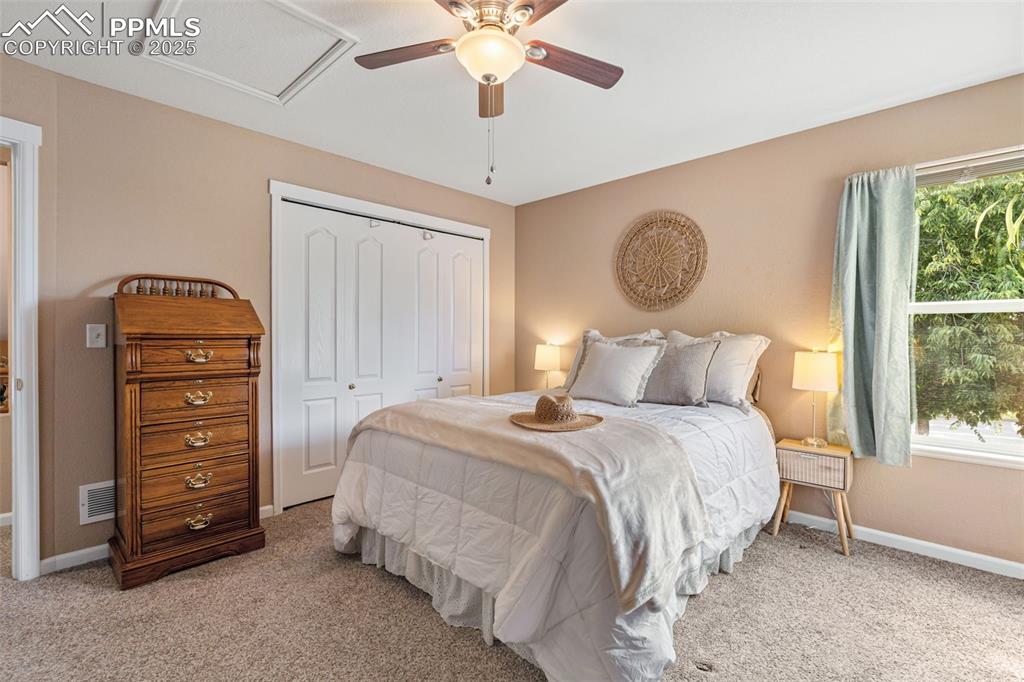 Image 12 of 36: Bedroom featuring light carpet, a closet, and a ceiling fan