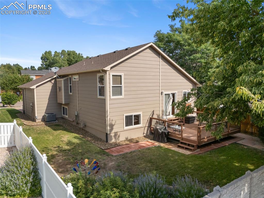 Image 29 of 36: Back of house with a fenced backyard, a wooden deck, and a shingled roof