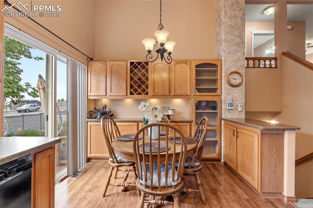 Image 8 of 36: Dining room with a chandelier, light wood-style floors, and a high ceiling