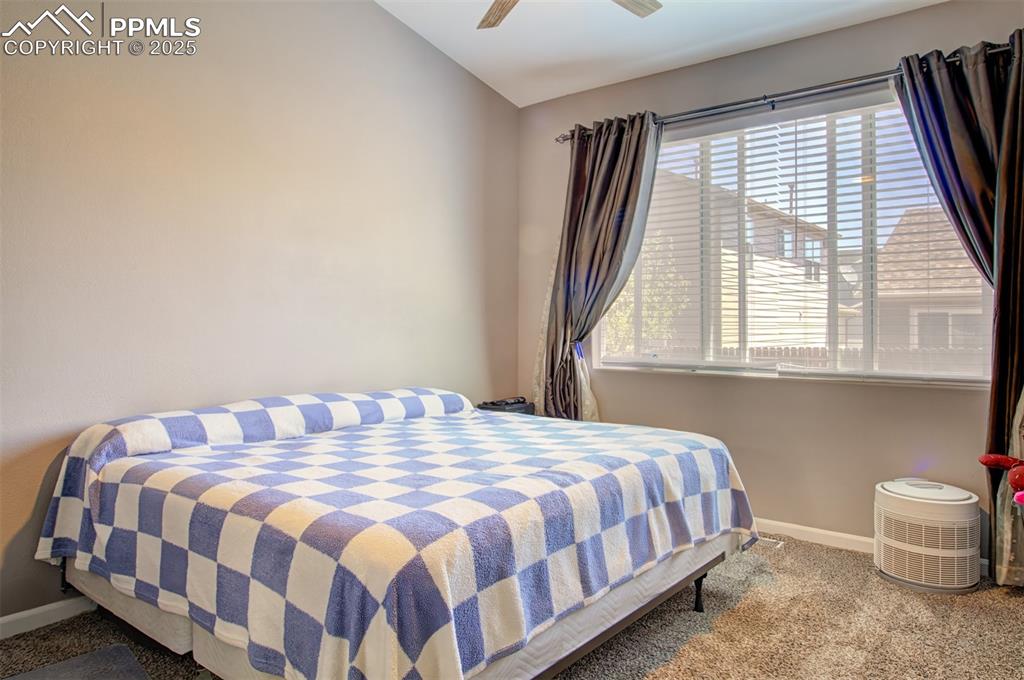 Image 13 of 21: Carpeted bedroom with a ceiling fan and vaulted ceiling