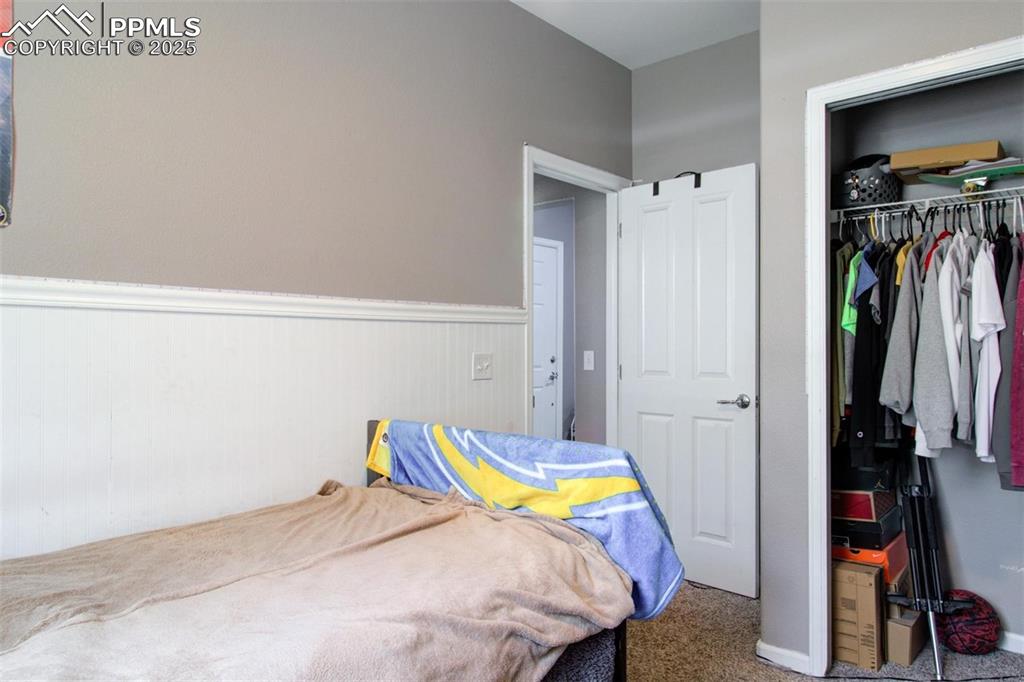 Image 16 of 21: Carpeted bedroom featuring wainscoting and a closet