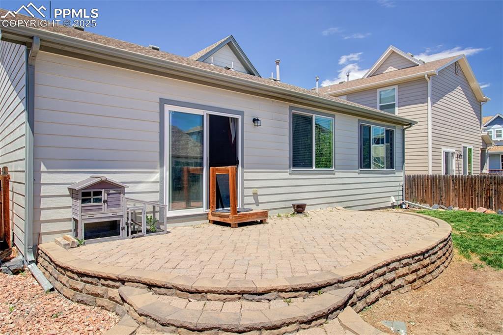 Image 19 of 21: Rear view of house with a patio area and a shingled roof
