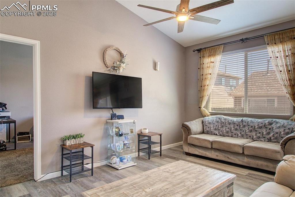 Image 4 of 21: Living room featuring wood finished floors, a ceiling fan, and vaulted ceil