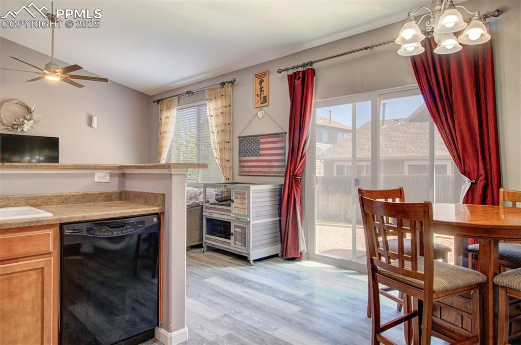Image 6 of 21: Kitchen featuring dishwasher, a chandelier, light countertops, light wood-t