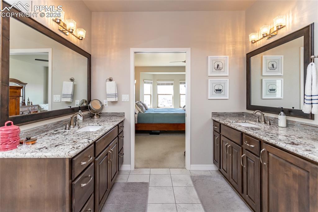 Image 27 of 50: Primary bathroom with large separate double sinks with plenty of cabinet sp