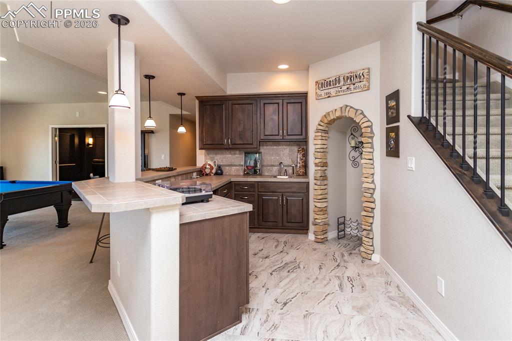 Image 31 of 50: Wet bar with wine fridge and space to add another larger refrigerator