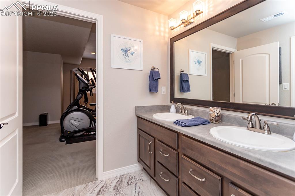Image 41 of 50: Double-sink basement bathroom adjoins to hall & fourth bedroom
