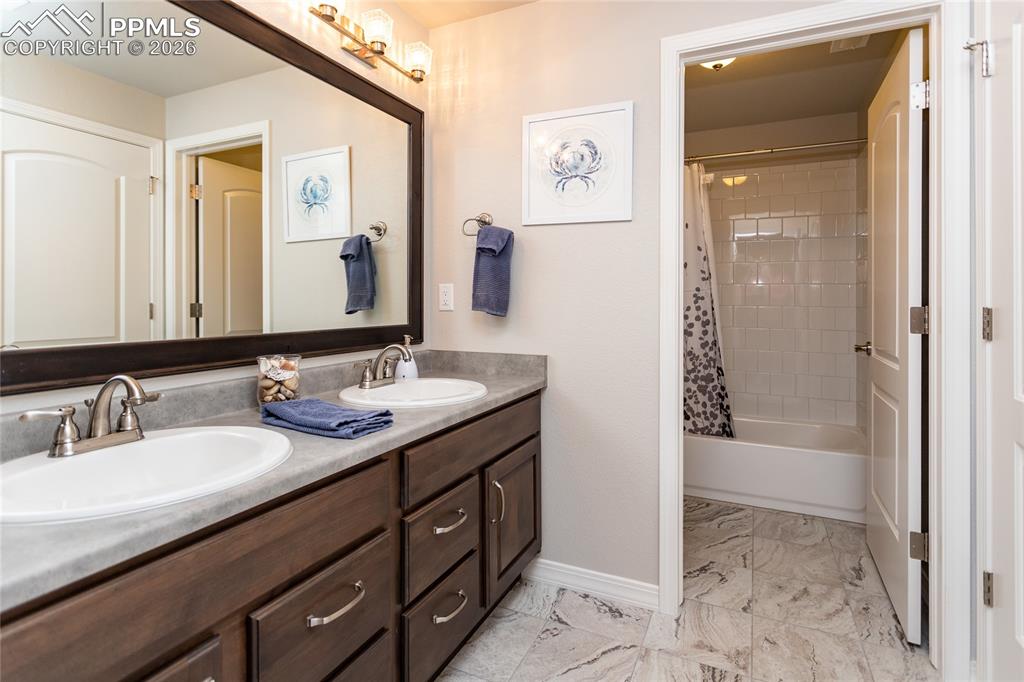 Image 42 of 50: Double-sink basement bathroom adjoins to hall & fourth bedroom & separates 