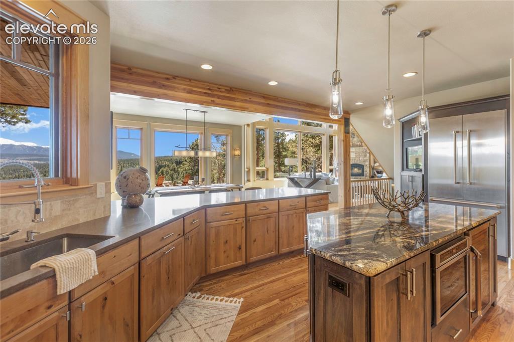Image 11 of 36: Gourmet kitchen with natural wood cabinetry, stainless steel appliances, an