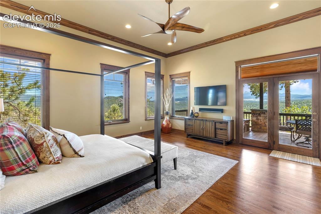 Image 12 of 36: Luxurious primary suite with soaring ceilings, hardwood floors, a private c