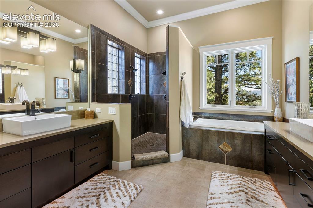 Image 14 of 36: Spacious bathroom featuring dual dark wood vanities with vessel sinks and l