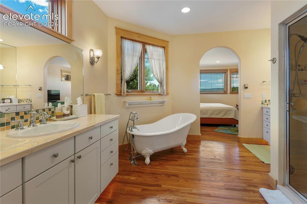 Image 17 of 36: Secondary suite bathroom with a clawfoot soaking tub, separate shower, and