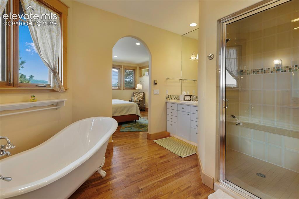 Image 18 of 36: Bathroom with a freestanding clawfoot tub and a glass-enclosed shower with