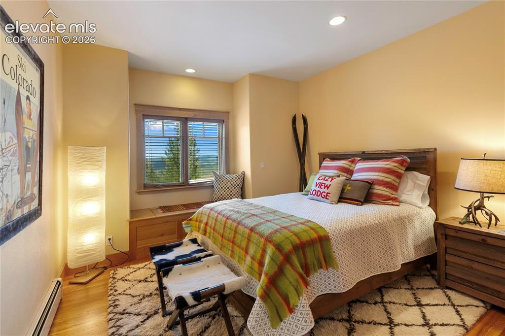Image 19 of 36: Bedroom featuring a built-in window seat with storage, wood-finish flooring