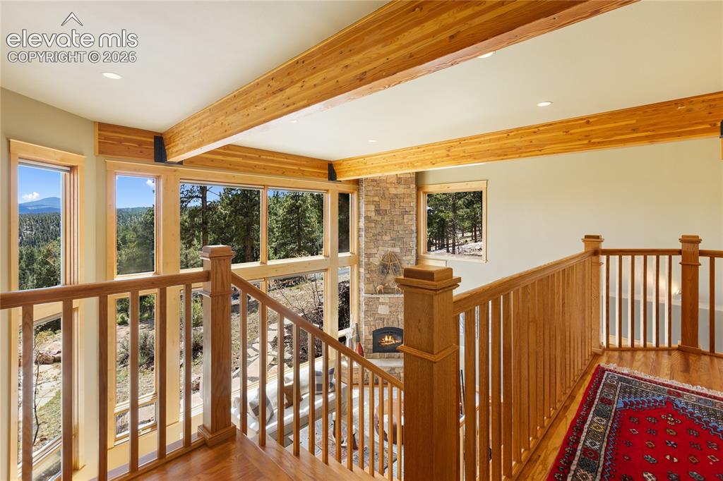 Image 24 of 36: Wood-finish flooring and natural wood railings define this upper-level land