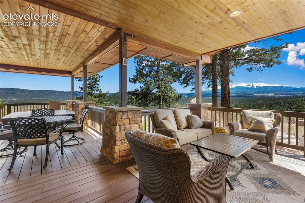 Image 33 of 36: Expansive covered deck featuring a wood-plank ceiling, recessed lighting, w