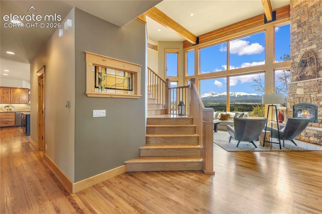 Image 4 of 36: Two-story living area featuring extensive natural wood-finish flooring, a p