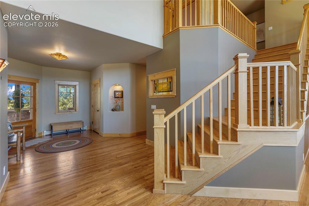 Image 5 of 36: Two-story entryway featuring wood-finish flooring, a wood staircase with ba