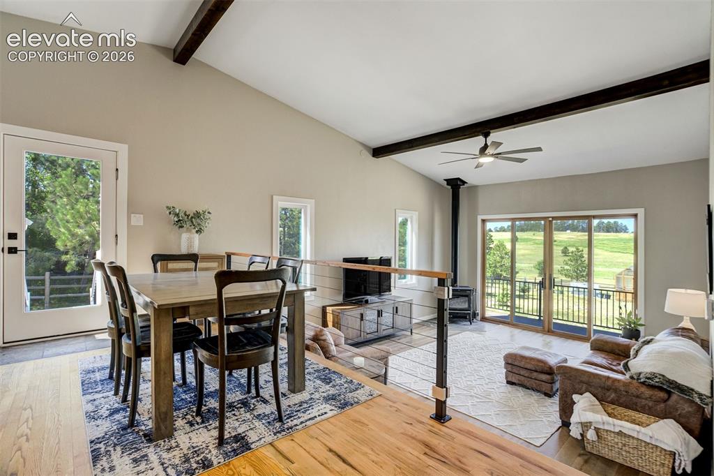 Image 12 of 50: Living area featuring a vaulted ceiling with exposed wood beams and a ceili