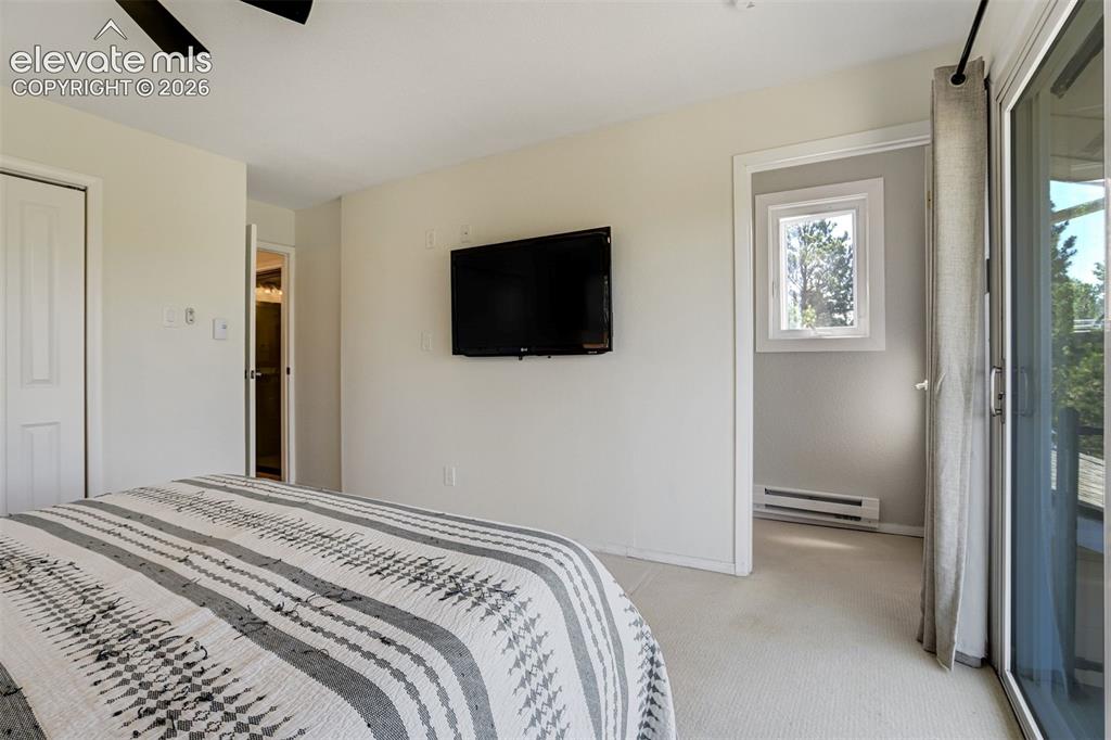 Image 22 of 50: Virtually Staged Primary bedroom with a sliding glass door and an additiona