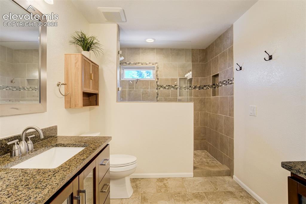Image 24 of 50: Primary bath with 2 separate vanities featuring a dark wood-finish cabinet