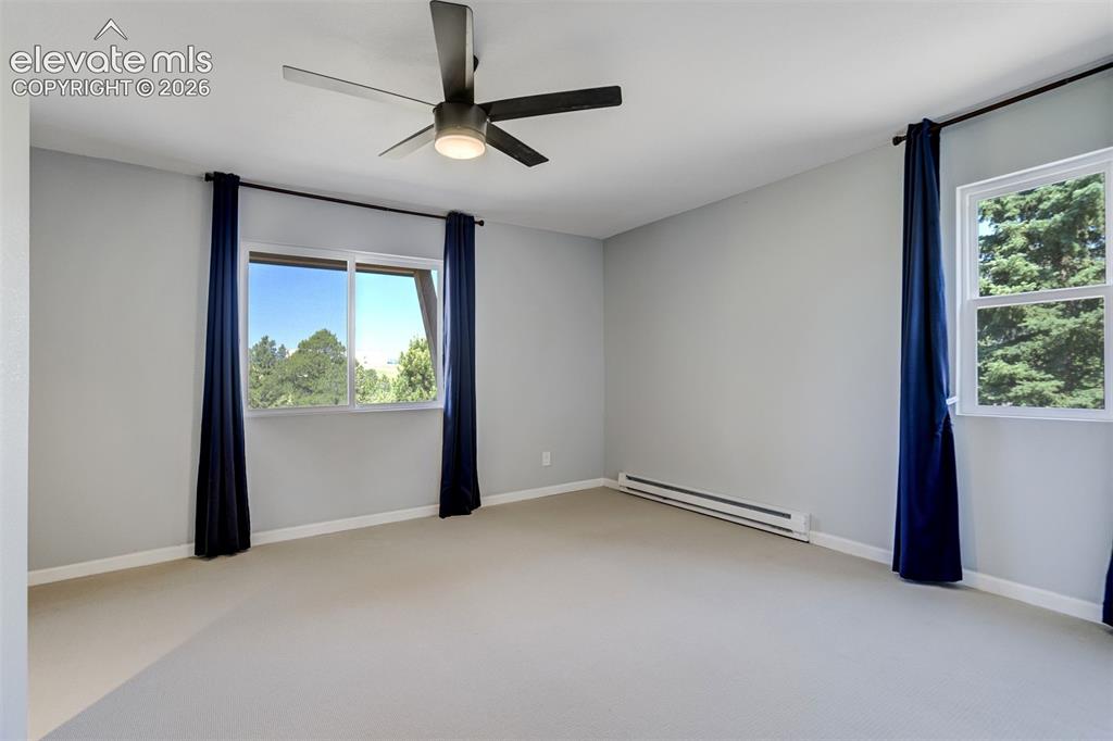 Image 29 of 50: Virtually Staged Spacious main level bedroom featuring light-colored walls