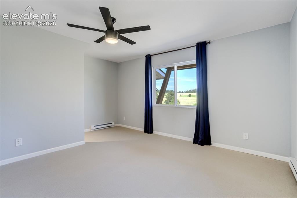 Image 31 of 50: Virtually Staged Spacious main level bedroom featuring light-toned walls, a