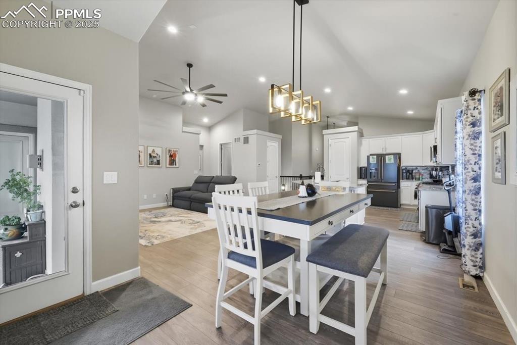 Image 12 of 47: Dining area with light wood-style floors, vaulted ceiling, recessed lightin