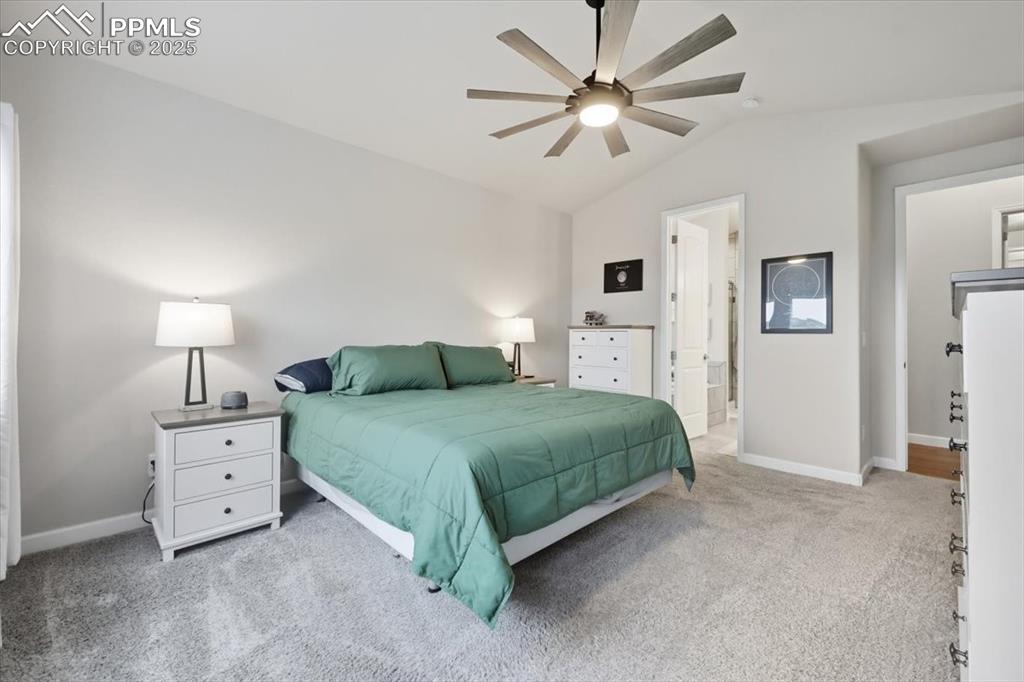 Image 22 of 47: Bedroom with light carpet, lofted ceiling, a ceiling fan, and ensuite bathr
