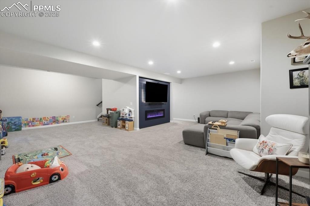 Image 29 of 47: Living area featuring carpet flooring, recessed lighting, and a glass cover